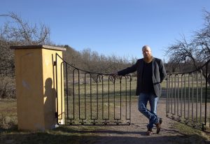 Kirjailija Heikki Kännö Brinkhallin kartanon puutarhan portilla.