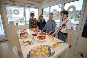 myyntipöydällä leivonnaisia ja myynnin järjestäneet neljä naista seisoo pöydän takana
