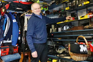 mies esittelee hyllyllä olevia esineitä