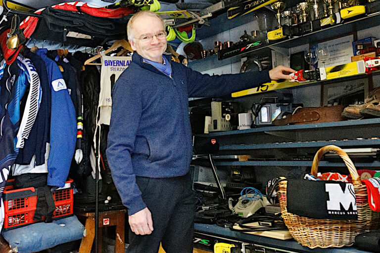 mies esittelee hyllyllä olevia esineitä