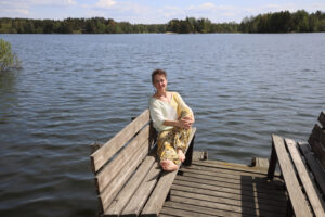 nainen istuu laiturilla ja katsoo kameraan