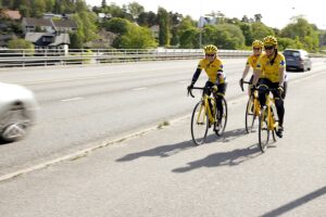 kolme pyöräilijää kilpa-asuissa