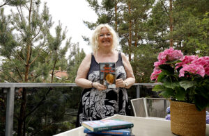 nainen esittelee kirjoittamaansa kirjaa